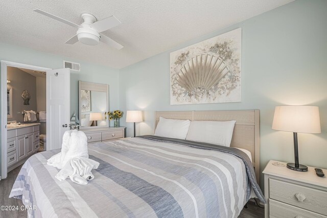 bedroom featuring ensuite bath, ceiling fan, dark hardwood / wood-style floors, and a textured ceiling