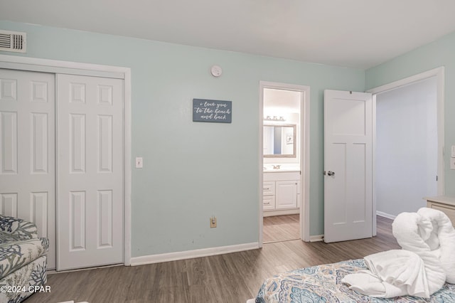 bedroom featuring light hardwood / wood-style floors, a closet, and ensuite bathroom