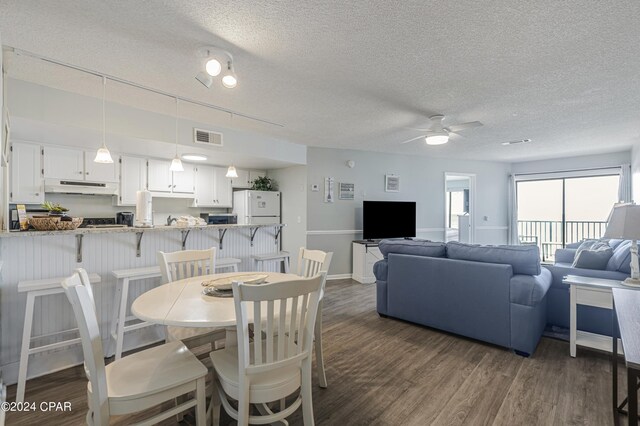 dining area featuring a textured ceiling, dark hardwood / wood-style flooring, and ceiling fan