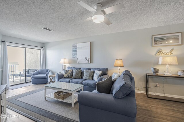 living room with a textured ceiling, dark hardwood / wood-style flooring, and ceiling fan