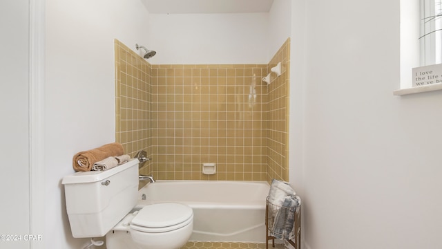 bathroom with toilet and tiled shower / bath