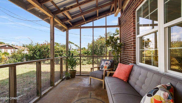 unfurnished sunroom featuring vaulted ceiling with beams and plenty of natural light