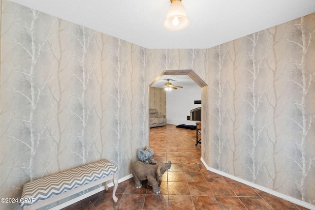 interior space with arched walkways and wallpapered walls