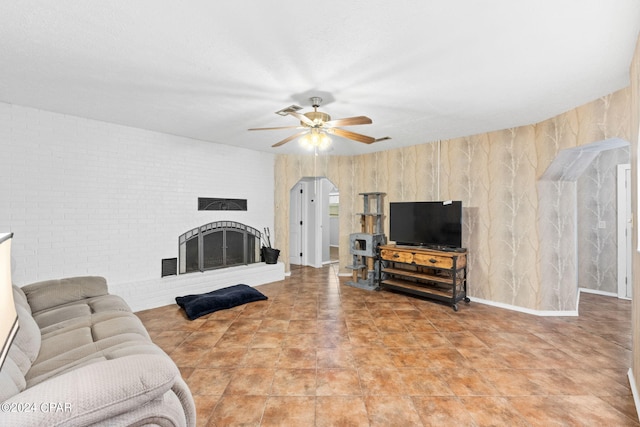 living room featuring a ceiling fan and a brick fireplace