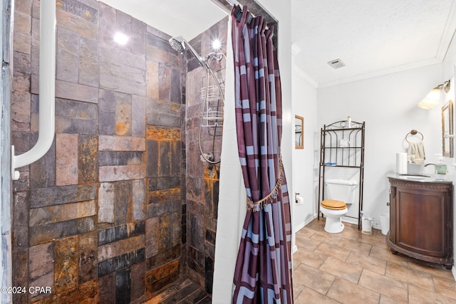 full bathroom featuring toilet, a tile shower, baseboards, vanity, and ornamental molding