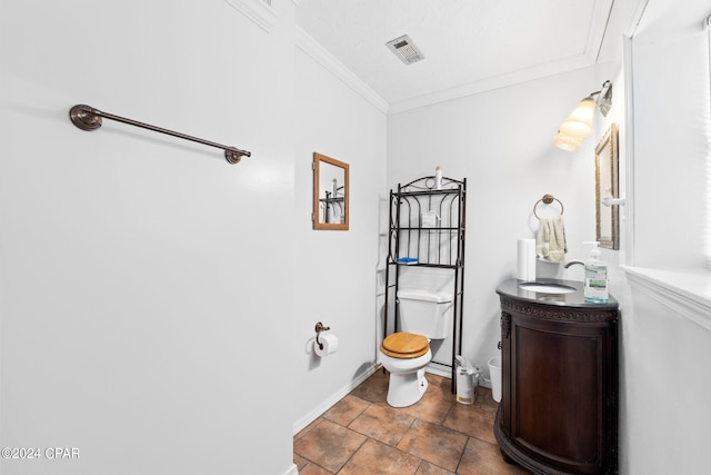 bathroom featuring toilet, baseboards, visible vents, vanity, and crown molding
