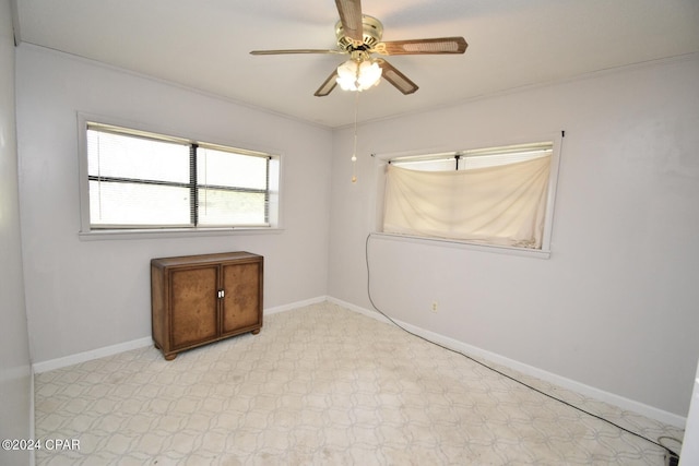 empty room with ceiling fan and crown molding