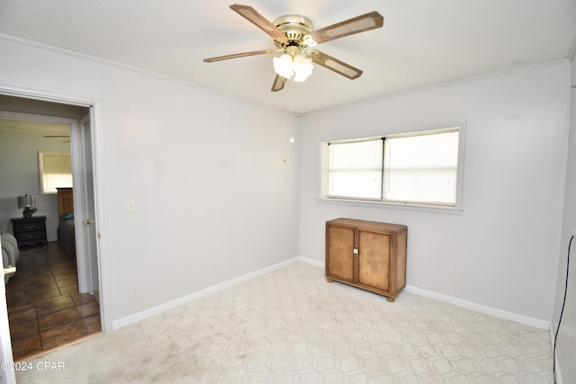 spare room featuring baseboards, ornamental molding, and ceiling fan