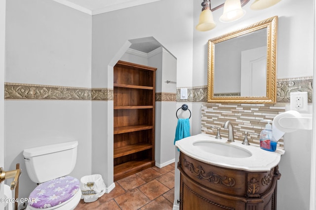 bathroom featuring backsplash, ornamental molding, vanity, tile patterned flooring, and toilet