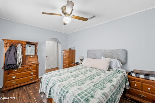 bedroom featuring baseboards, dark wood-style flooring, visible vents, crown molding, and arched walkways
