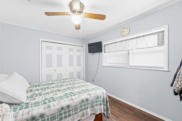 bedroom featuring a closet, wood finished floors, baseboards, and ornamental molding
