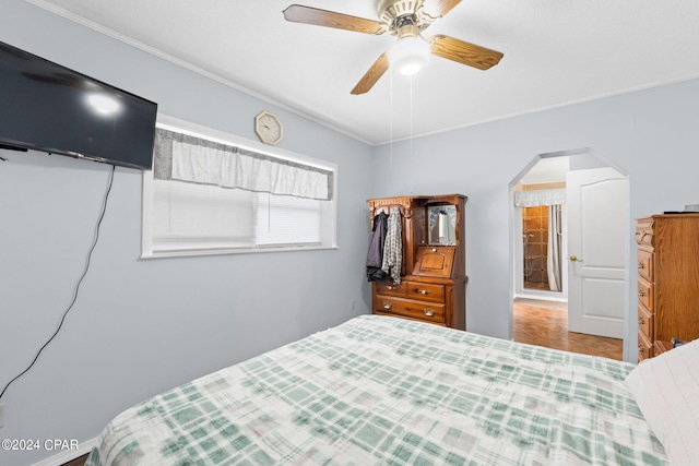 bedroom featuring ornamental molding, a ceiling fan, and arched walkways
