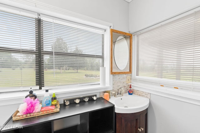 bathroom featuring a healthy amount of sunlight, vanity, and tasteful backsplash