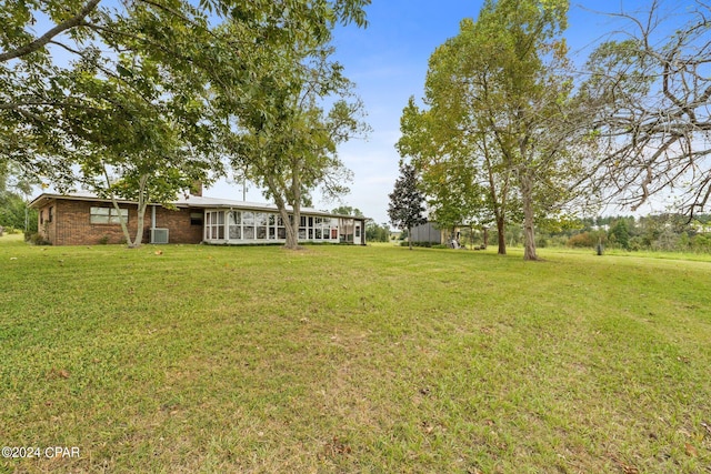 view of yard featuring central AC and a sunroom