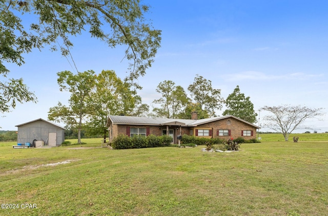 single story home featuring a chimney, brick siding, and a front lawn