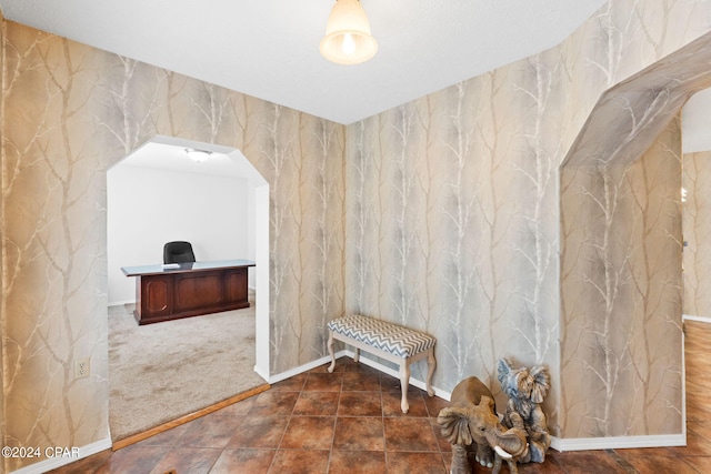 interior space with wallpapered walls and arched walkways