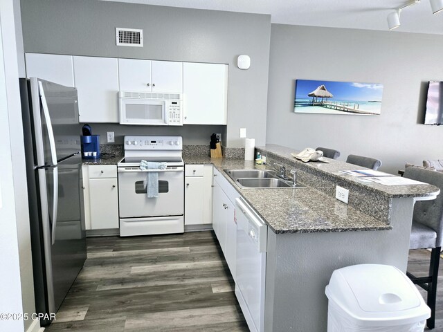 kitchen featuring a textured ceiling, white cabinetry, dark hardwood / wood-style floors, sink, and white appliances