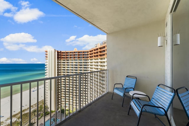 balcony featuring a beach view and a water view