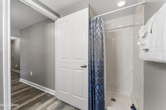 bathroom with a shower with curtain and hardwood / wood-style flooring