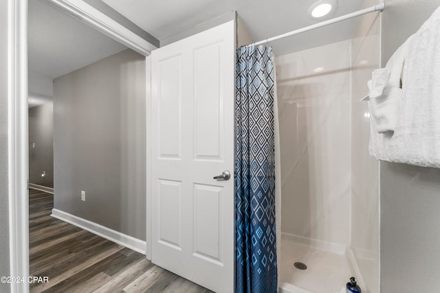 bathroom featuring wood-type flooring and curtained shower