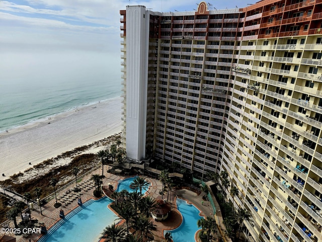 view of building exterior with a water view and a view of the beach