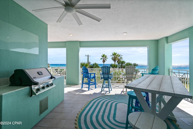 view of patio featuring ceiling fan, a grill, and a water view