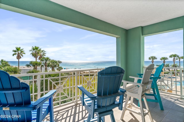 balcony featuring a water view and a beach view