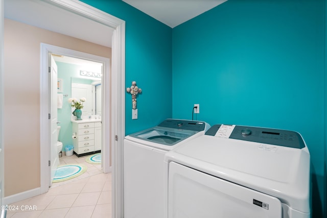 laundry area with washer and dryer and light tile patterned floors