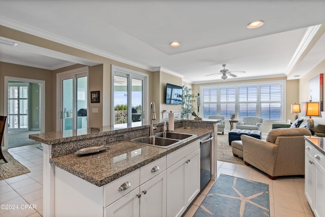 kitchen with a center island with sink, sink, ceiling fan, light tile patterned flooring, and white cabinetry