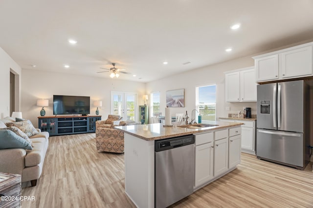 kitchen featuring an island with sink, appliances with stainless steel finishes, white cabinets, and open floor plan