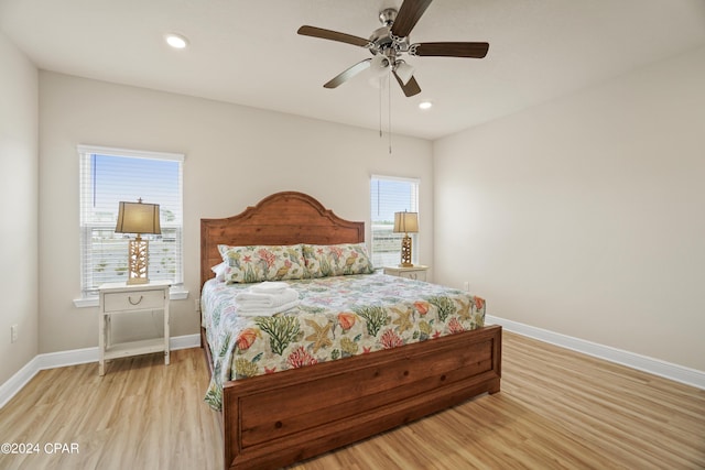 bedroom featuring multiple windows, ceiling fan, and light wood-type flooring