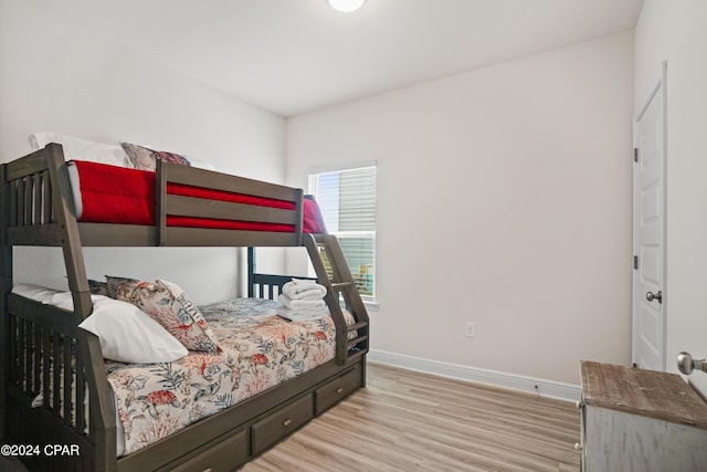 bedroom with light wood finished floors and baseboards