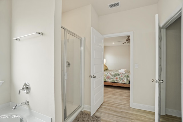 full bathroom featuring connected bathroom, wood finished floors, visible vents, baseboards, and a shower stall