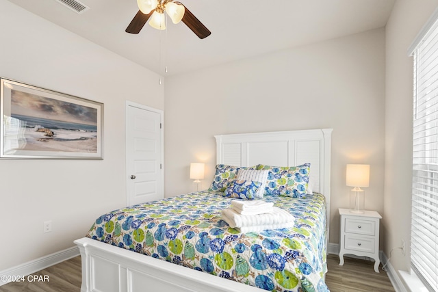 bedroom with ceiling fan, wood finished floors, and baseboards