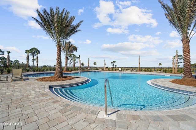 pool with a patio and fence