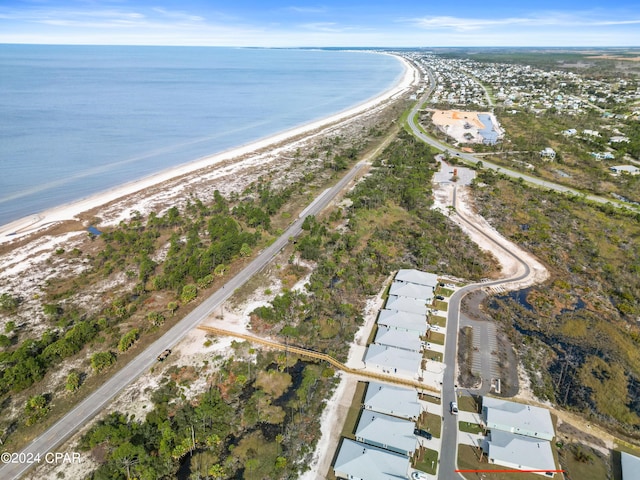 birds eye view of property featuring a water view and a beach view