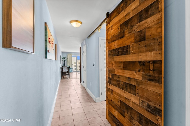 hall with light tile patterned floors and a barn door