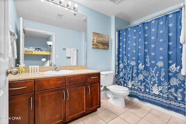 bathroom featuring vanity, toilet, and tile patterned flooring