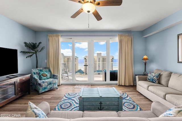 living room with light hardwood / wood-style flooring and ceiling fan