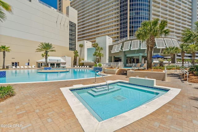 view of pool with a hot tub and a patio area