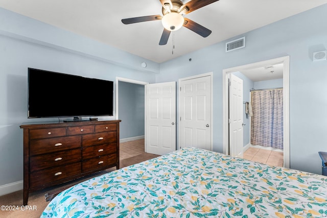 tiled bedroom featuring ensuite bath and ceiling fan