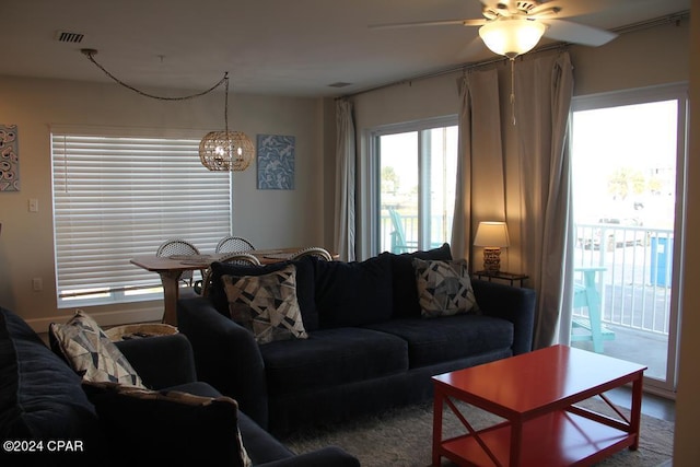 living room featuring ceiling fan with notable chandelier