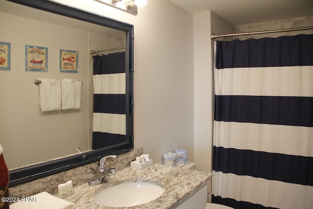 bathroom featuring vanity, curtained shower, and toilet