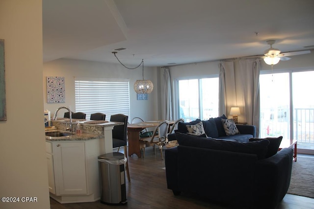 living room with ceiling fan, dark wood-type flooring, and sink