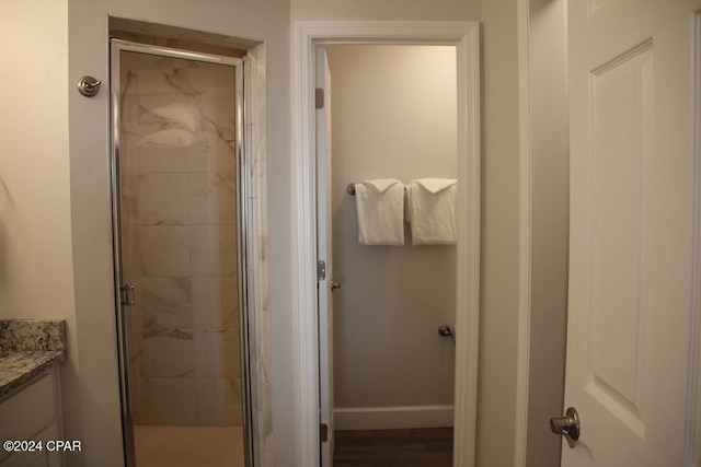 bathroom with hardwood / wood-style floors, vanity, and walk in shower