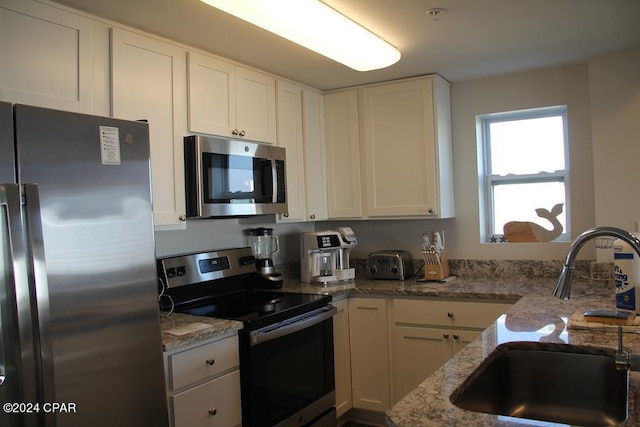 kitchen featuring sink, white cabinets, and stainless steel appliances