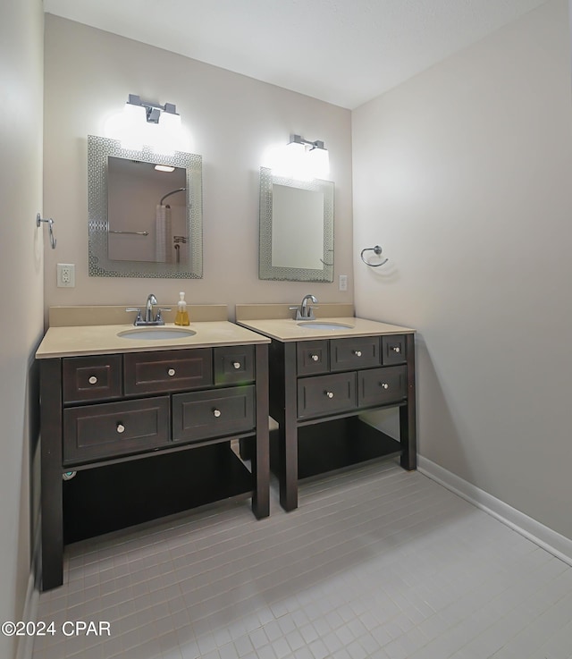 full bathroom featuring baseboards, two vanities, and a sink