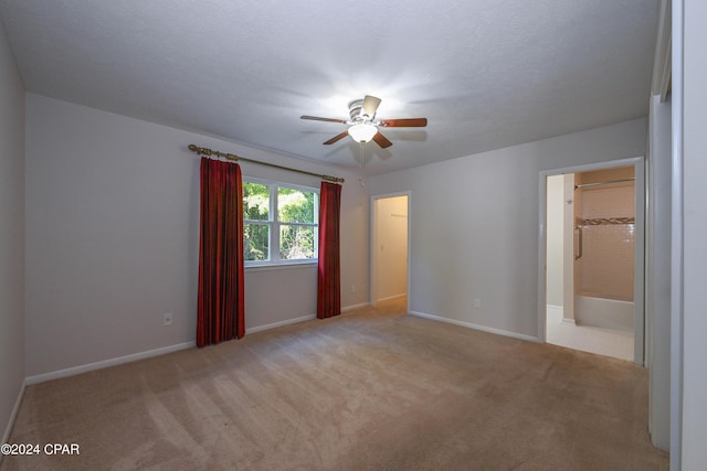 empty room featuring ceiling fan, a textured ceiling, carpet flooring, and baseboards