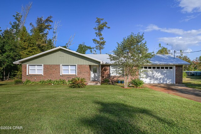 ranch-style house featuring driveway, a front lawn, an attached garage, and brick siding