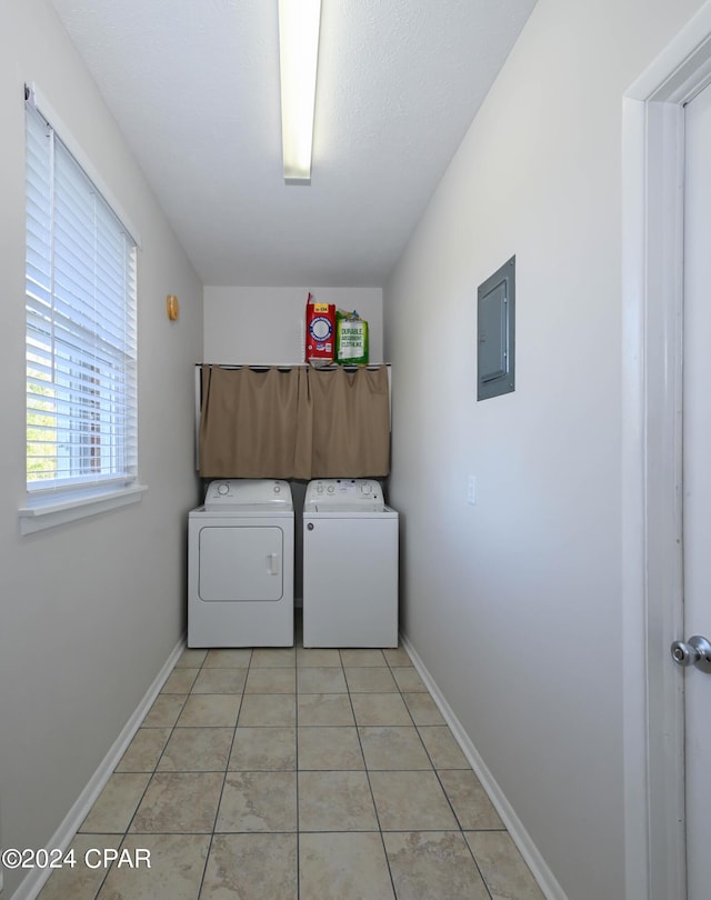 laundry room featuring washer and clothes dryer, light tile patterned flooring, laundry area, electric panel, and baseboards